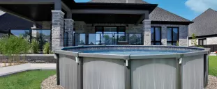 An above ground pool in the back yard of a house.