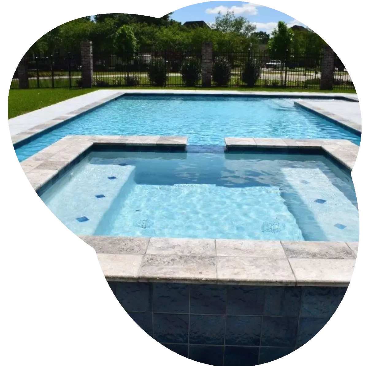 A gunite pool with a hot tub attached.